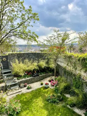 a garden with flowers and a stone wall at Romantic stay overlooking Prague in Prague