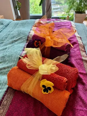 a pile of towels with flowers on a bed at Romantic stay overlooking Prague in Prague