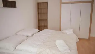 a white bed with three pillows on top of it at Rezidence Kbely - Free Parking in Prague