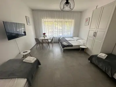 a room with two beds and a couch and a table at Rezidence Kbely - Free Parking in Prague