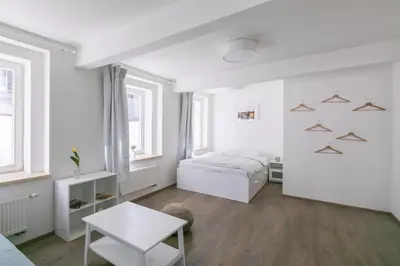 a white bedroom with a bed and a table at Cozy apartment in quiet courtyard near Charles Bridge in Prague