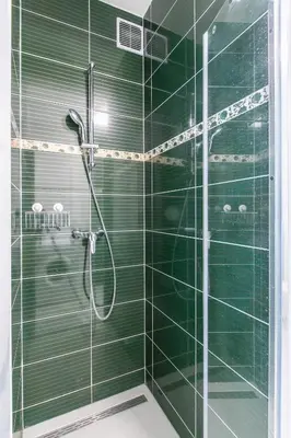 a bathroom with a shower with green tiles at Cozy apartment in quiet courtyard near Charles Bridge in Prague