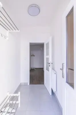 a hallway with white walls and a white floor at Cozy apartment in quiet courtyard near Charles Bridge in Prague
