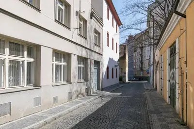 an alley in an old town with white buildings at Cozy apartment in quiet courtyard near Charles Bridge in Prague