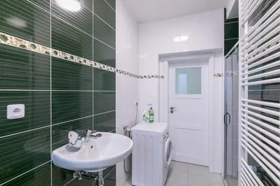 a green and white bathroom with a sink and a toilet at Cozy apartment in quiet courtyard near Charles Bridge in Prague