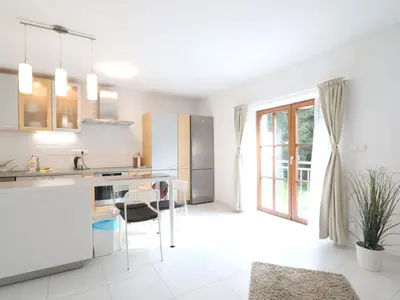 a kitchen with white cabinets and a table and chairs at Holiday Home Posázaví by Interhome in Jílové u Prahy