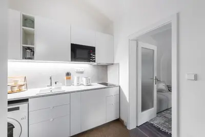 a white kitchen with a sink and a washing machine at George Apartment in Prague