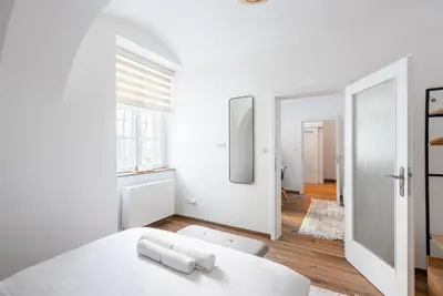 a white room with a white table and a mirror at George Apartment in Prague