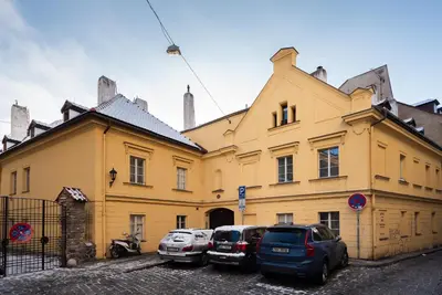a yellow building with cars parked in front of it at George Apartment in Prague