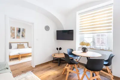 a living room with a table and chairs and a bed at George Apartment in Prague