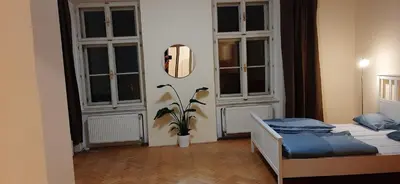 a bedroom with a bed and two large windows at Apartman Josef in Prague