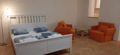a bedroom with a bed and two orange chairs at Apartman Josef in Prague