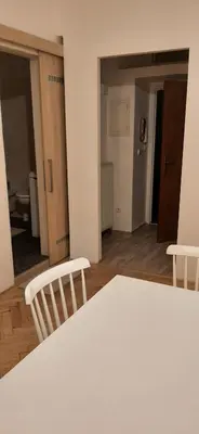 a room with a table and two chairs and a hallway at Apartman Josef in Prague