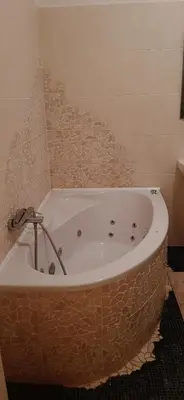 a bath tub in a bathroom with a tile wall at Apartman Josef in Prague