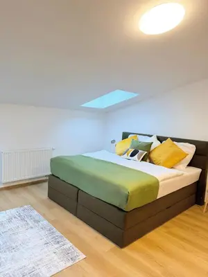 a bedroom with a bed with yellow and green pillows at Parkside Apartments Prague in Prague