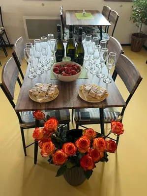 a wooden table with wine glasses and roses on it at Zelený grunt in Dřínov