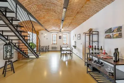 an industrial loft with a wooden ceiling and stairs at Zelený grunt in Dřínov