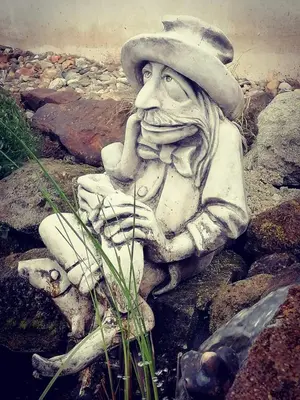 a statue of a man sitting on some rocks at Zelený grunt in Dřínov