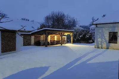 a snow covered yard with a gazebo at degustační dům in Babice