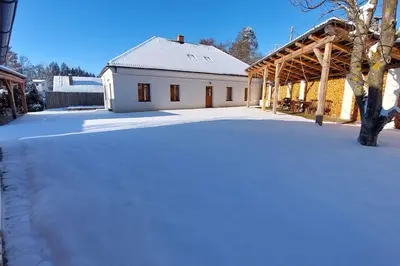 a white house with snow on the ground at degustační dům in Babice