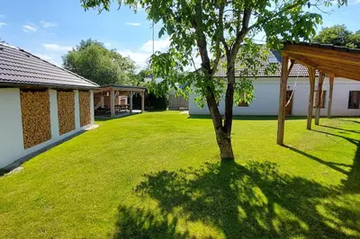 a green yard with a tree and a building at degustační dům in Babice