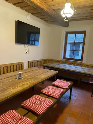 a dining room with a large wooden table and benches at Hájovna Libice in Rybníky