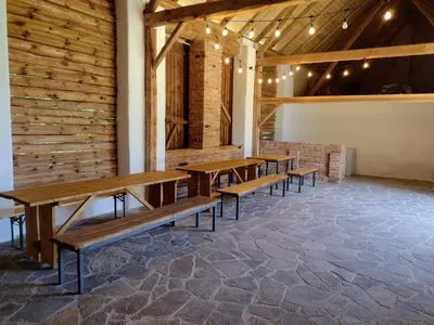 a row of wooden benches in a room with a brick wall at Hájovna Libice in Rybníky