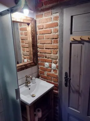 a bathroom with a sink and a brick wall at Hájovna Libice in Rybníky