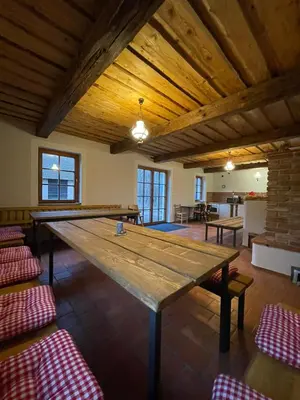 a large wooden table in a room with chairs at Hájovna Libice in Rybníky