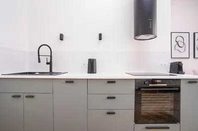 a kitchen with white cabinets and a sink at Prague Days - One-bedroom Apartment with Netflix and Balcony in Vinohrady in Prague