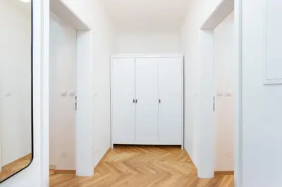 a room with white doors and a wooden floor at Prague Days - One-bedroom Apartment with Netflix and Balcony in Vinohrady in Prague