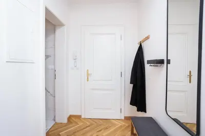 a hallway with two white doors and a rug at Prague Days - One-bedroom Apartment with Netflix and Balcony in Vinohrady in Prague