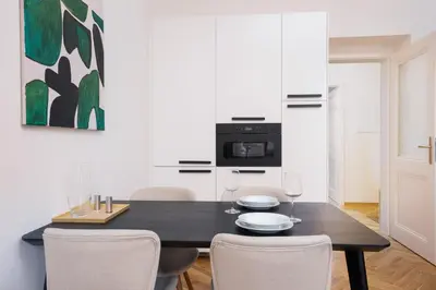 a dining room with a black table and chairs at Prague Days - One-bedroom Apartment with Netflix and Balcony in Vinohrady in Prague