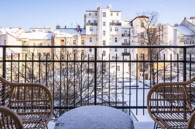a balcony with a table and chairs and a view of buildings at Prague Days - One-bedroom Apartment with Netflix and Balcony in Vinohrady in Prague