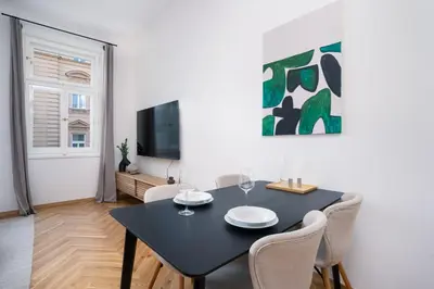 a dining room with a black table and chairs at Prague Days - One-bedroom Apartment with Netflix and Balcony in Vinohrady in Prague