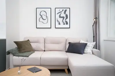 a living room with a white couch and a table at Prague Days - One-bedroom Apartment with Netflix and Balcony in Vinohrady in Prague
