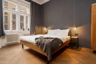 a bedroom with a bed and two chairs and a window at Prague Days - Family-friendly Apartment with Netflix in quiet Vinohrady in Prague