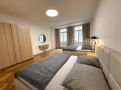 a bedroom with two beds and a flat screen tv at Spacious Apartment on Wenceslas Square in Prague