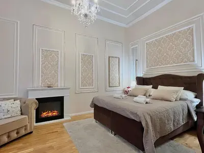 a bedroom with a bed with a fireplace and a chandelier at AngeloRoma Apartment in the center in Prague