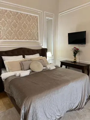 a bedroom with a large bed with pillows and a television at AngeloRoma Apartment in the center in Prague