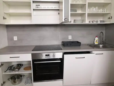 a kitchen with white cabinets and a black oven at Brand New Apartments in Prague