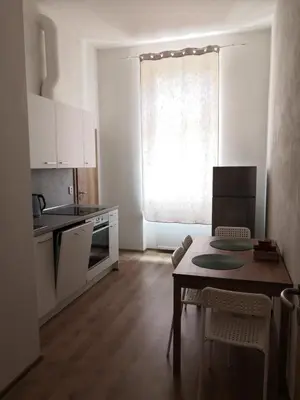 a small kitchen with a table and a dining room at Brand New Apartments in Prague