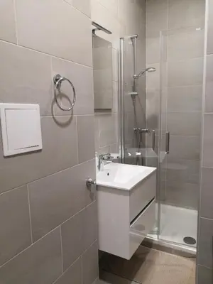 a bathroom with a white sink and a shower at Brand New Apartments in Prague