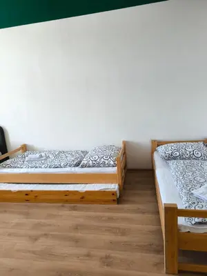 two beds in a room with wooden floors at Brand New Apartments in Prague