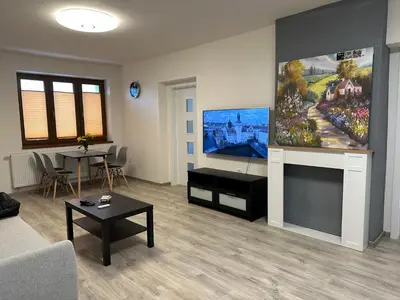 a living room with a large painting on the wall at Apartment Golden Prague 78 in Vestec