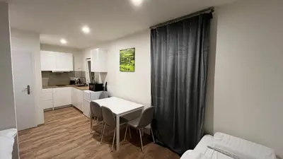 a room with a table and chairs and a kitchen at Apartment Golden Prague 78 in Vestec