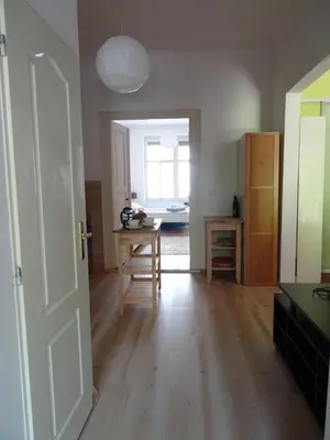 a room with a kitchen with a table and a door at Garden Apartment on Art Nouveau Street in Central Prague in Prague