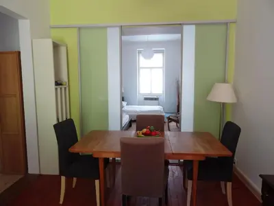 a dining room with a wooden table and chairs at Garden Apartment on Art Nouveau Street in Central Prague in Prague