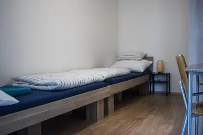 a bed sitting on a wooden bench in a room at Central Prague Vítkov - free parking in Prague