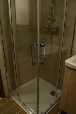 a shower with a glass door in a bathroom at Central Prague Vítkov - free parking in Prague